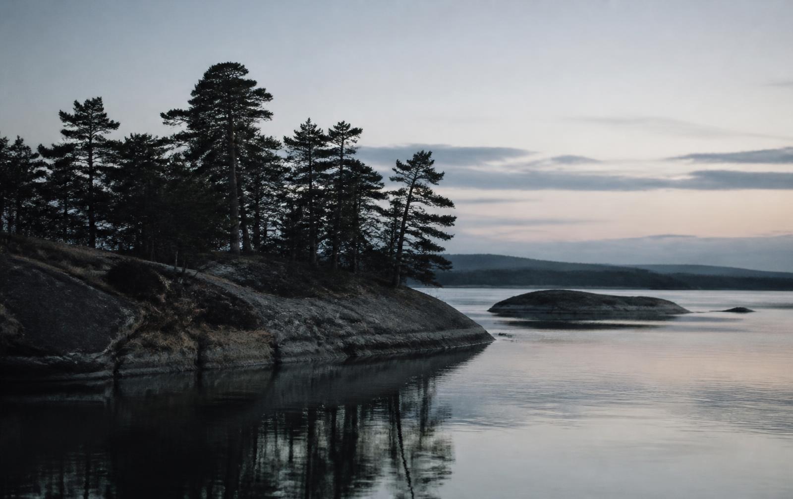 Finnish archipelago at dusk, pines and still water